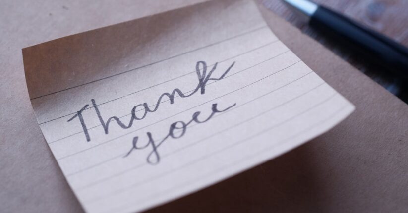 テンプレートを見ながら席札メッセージを手書きしている新婦。丁寧に文字を綴る様子。