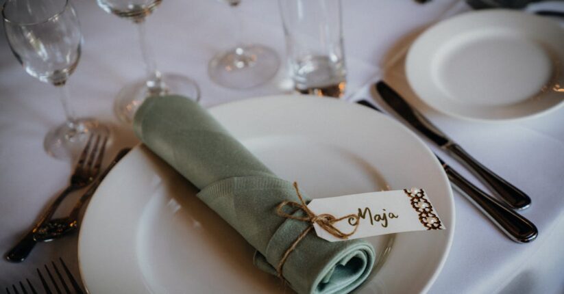 披露宴で席札メッセージを読み微笑むゲスト。温かく感動的な雰囲気。