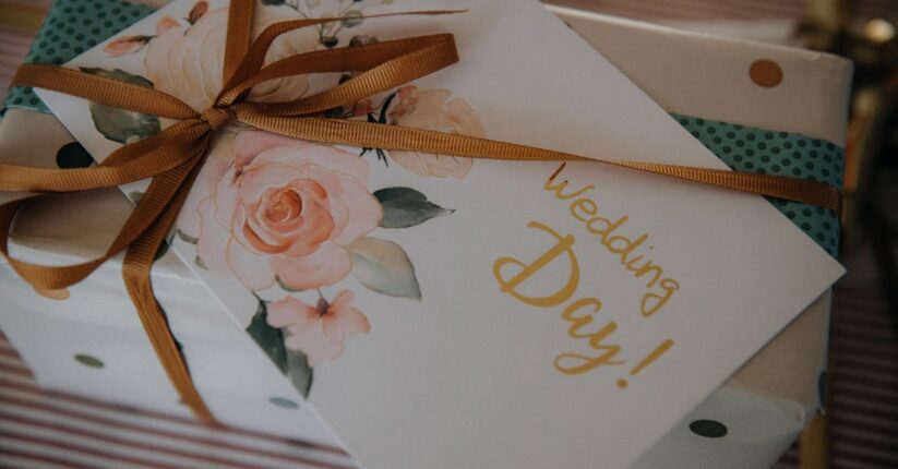 前撮りで手作りペーパーアイテムを撮影小物として使っているカット。封筒やタグを背景にした写真構成。