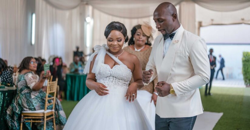 披露宴で席札メッセージを読みながら笑顔になる友人たちの様子。温かい雰囲気のテーブル。