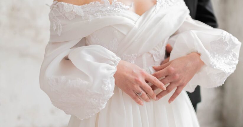 結婚式のマナー本を参考に席札メッセージを書く新婦。敬語や表現を確認している様子。