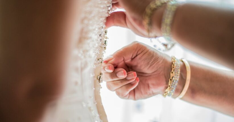 デザインは外注し、仕上げを手作りしている花嫁。机の上に印刷済みのカードとリボンが並ぶ。