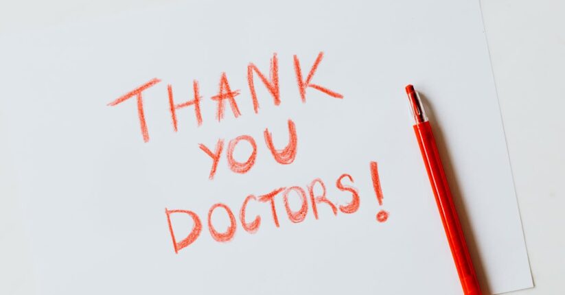 結婚式の席札メッセージに上司宛ての言葉を書いている様子。丁寧で上品な雰囲気のテーブルコーディネート。