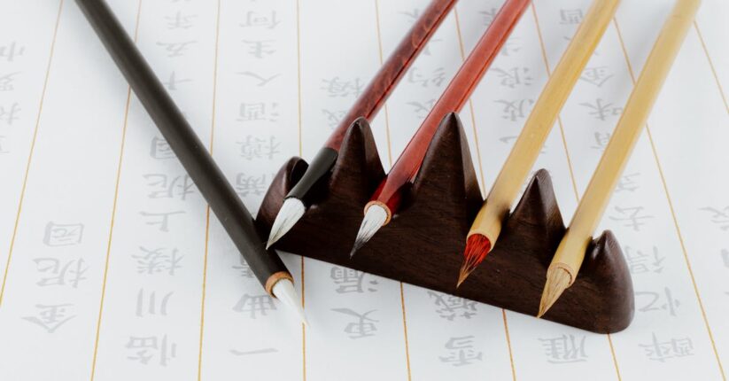 結婚式の席札メッセージを下書きしながら書く花嫁。ガイド線とペンで丁寧に整えている。