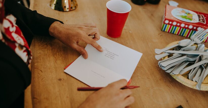 結婚式の席札に家族への感謝の言葉を書いている花嫁。温かく穏やかな雰囲気のテーブル。