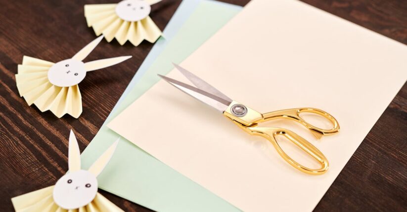 結婚式の手作りペーパーアイテムを準備する花嫁。招待状や席札がナチュラルな雰囲気で並んでいる。