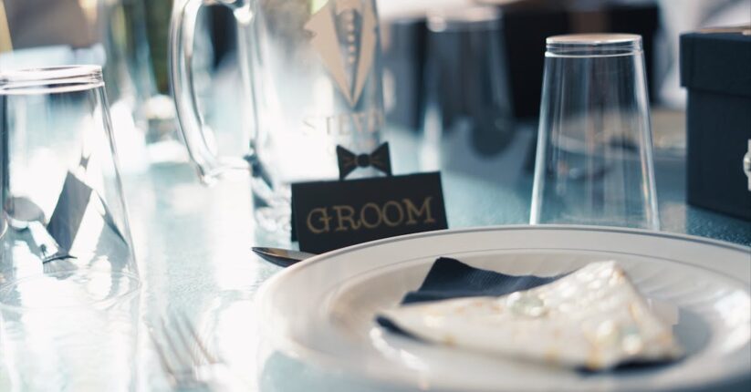 手作りの席札を丁寧に仕上げる新婦の手元。ナチュラルな素材とクラフト紙の組み合わせ。