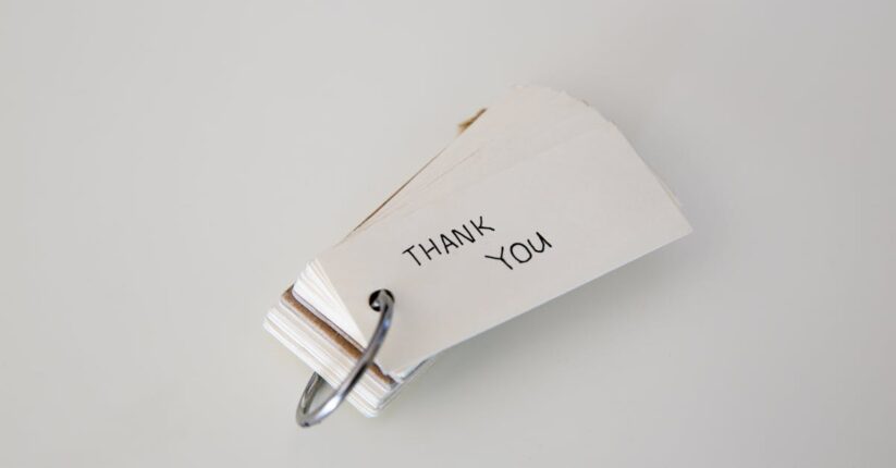 前向きなエールを込めた席札メッセージを手に笑顔のゲスト。温かい雰囲気の披露宴。